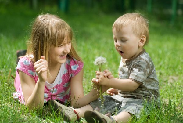 Children Outdoor. Happy Sister and Brother resting in the park