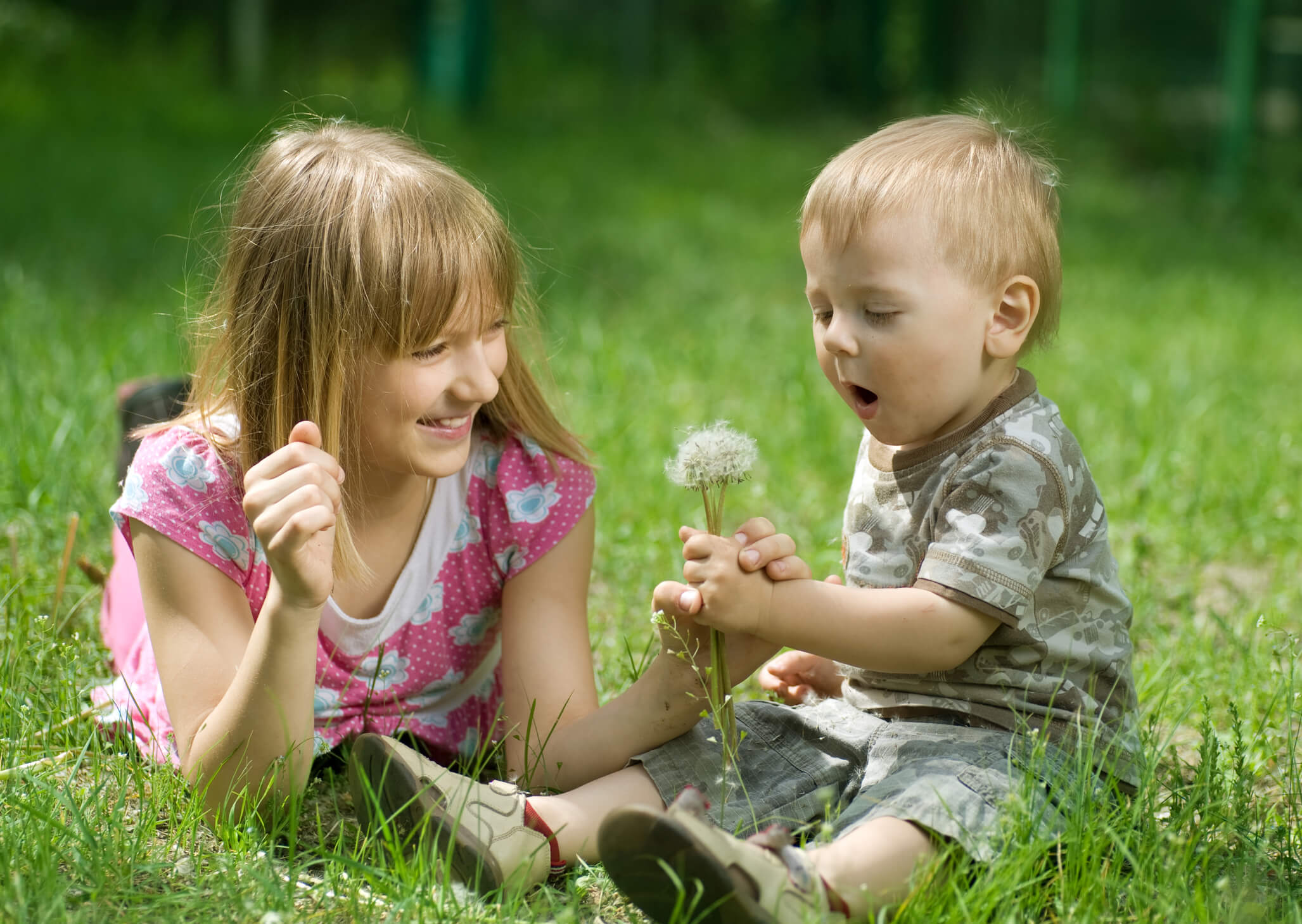 Children Outdoor. Happy Sister and Brother resting in the park