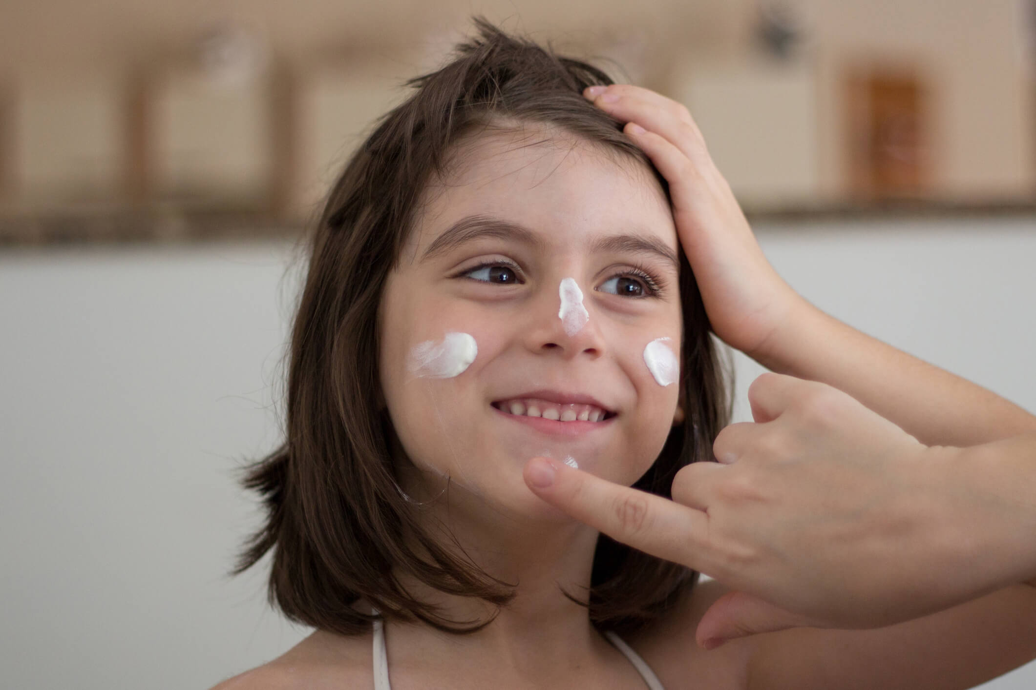 Mother Applying Sunscreen. Mum putting sun cream, sunscreen care or protection on child before going out in the sun