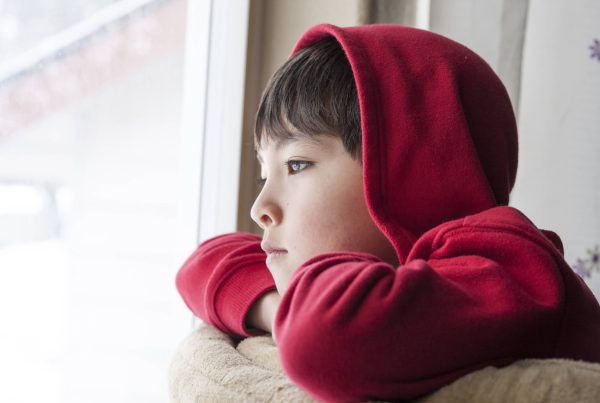 Boy looks outside. A young boy appears to be bored and stuck indoors.